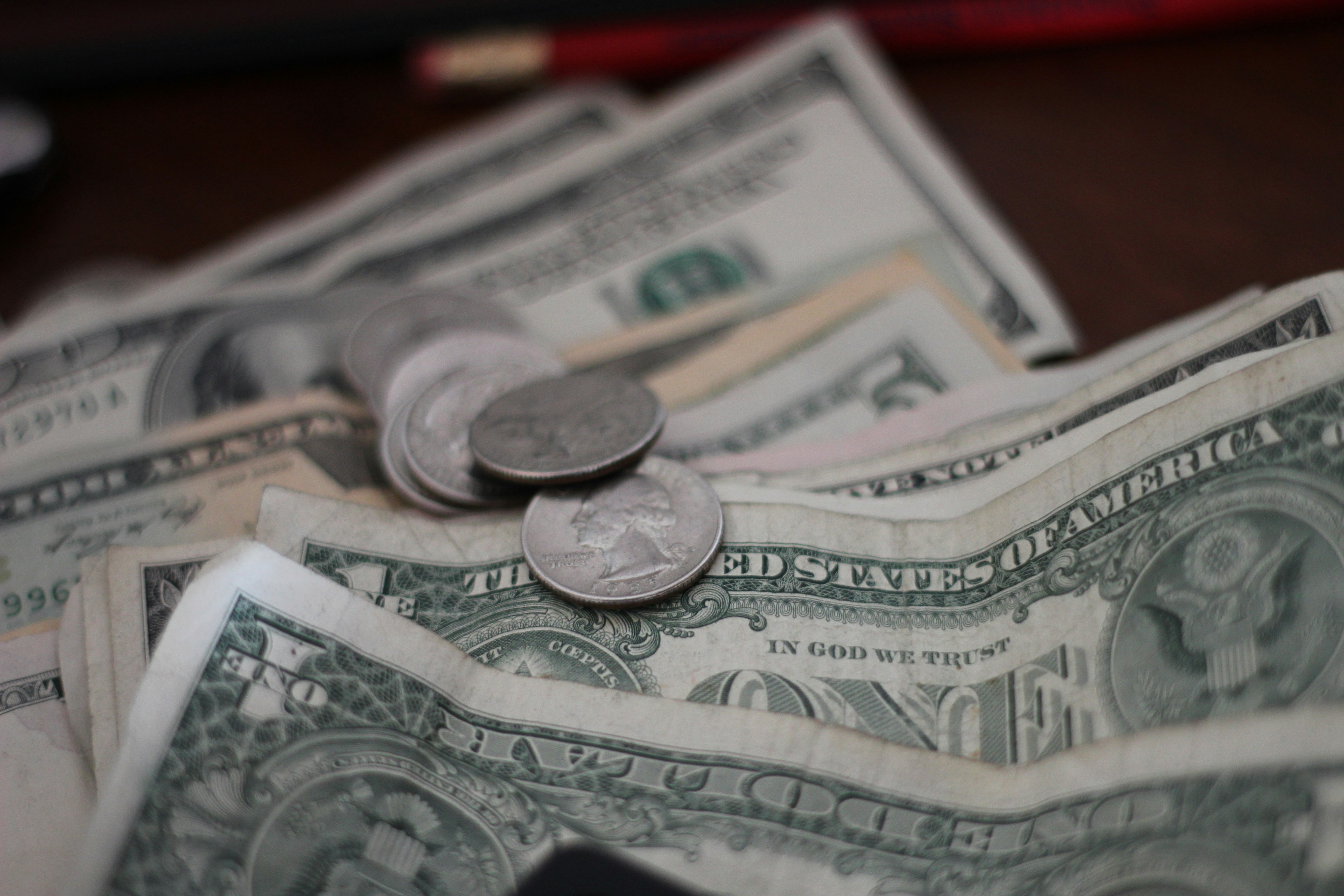 Close-up of US dollars and coins on table